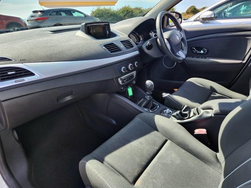 The front seats, steering wheel, and controls on a Glacier White Renault Megane Dynamique Tom Tom, viewed from the left side.