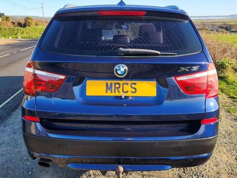 A Deepsea Blue BMW X3 viewed from behind
