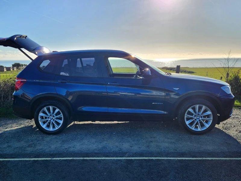 A Deepsea Blue BMW X3 viewed from the driver's side