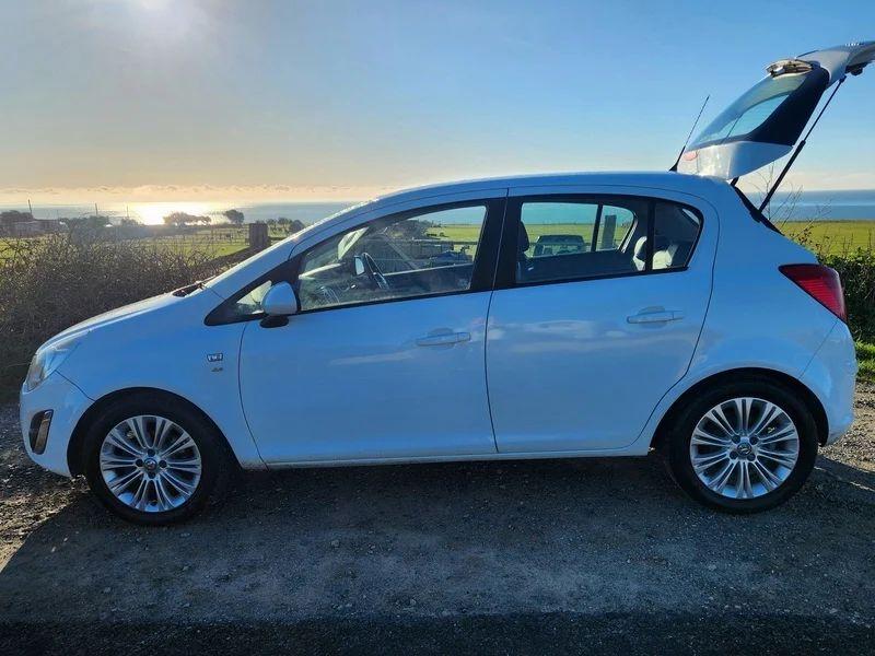 A white Vauxhall Corsa 1.4 SE viewed from the passenger side.
