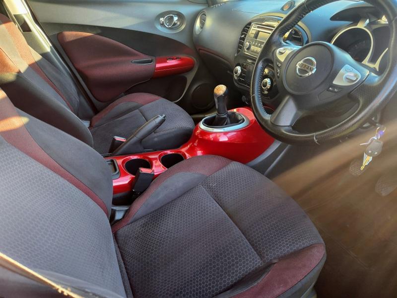 A cayenne red Nissan Juke Acente viewed from the driver seat.