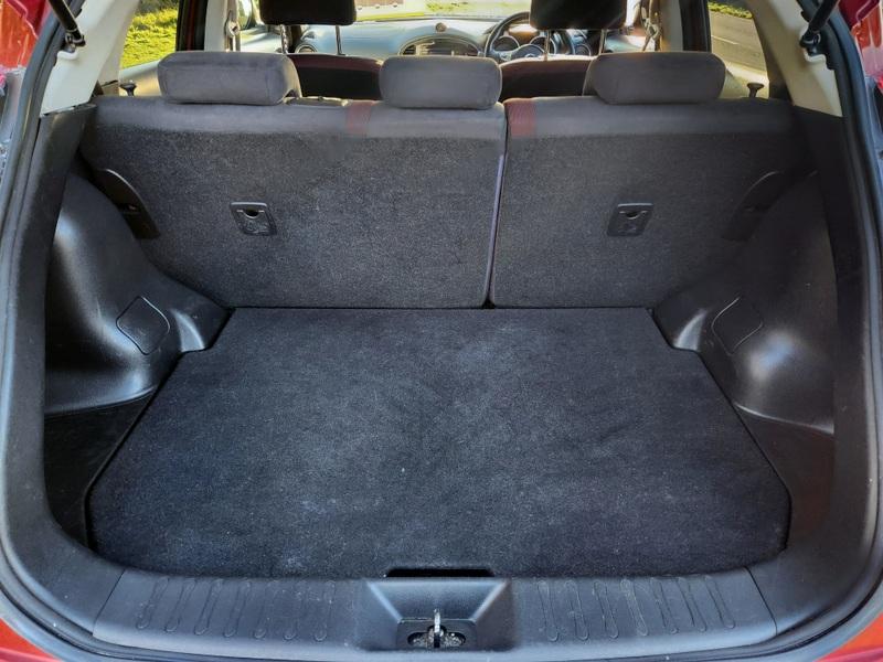The boot of a cayenne red Nissan Juk Acente viewed from behind