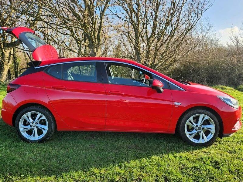A Power Red Vauxhall Astra viewed from the driver side