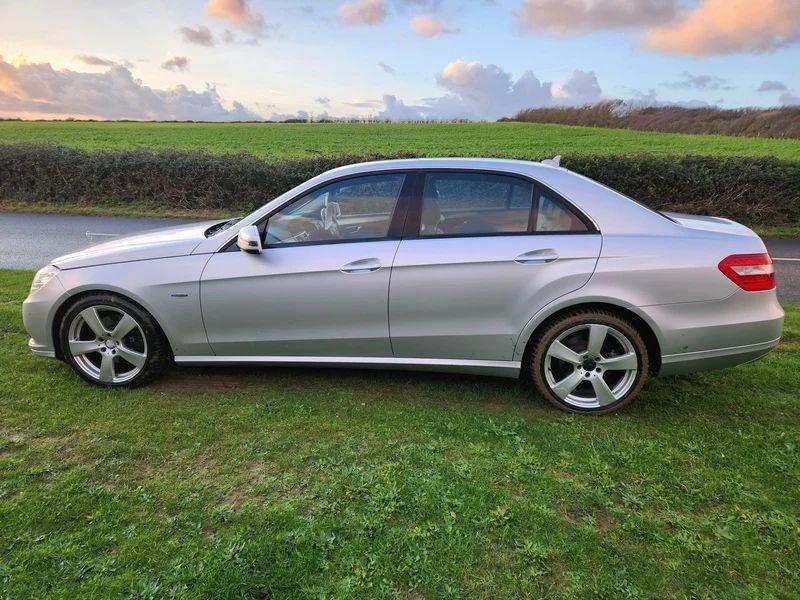 A  silver Mercedes viewed from the passenger side
