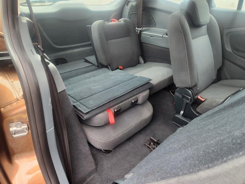 The interior of a brown Ford C Max viewed back from behind the driver door