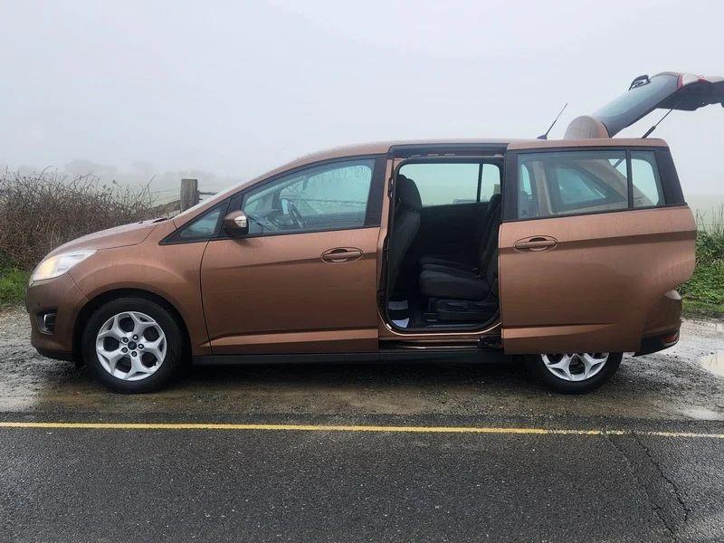 A brown Ford C Max, with the rear side door open, viewed from the passenger side