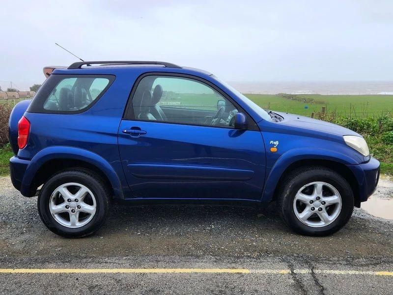 A Nebula Blue Metallic Toyota RAV4 viewed from the driver side