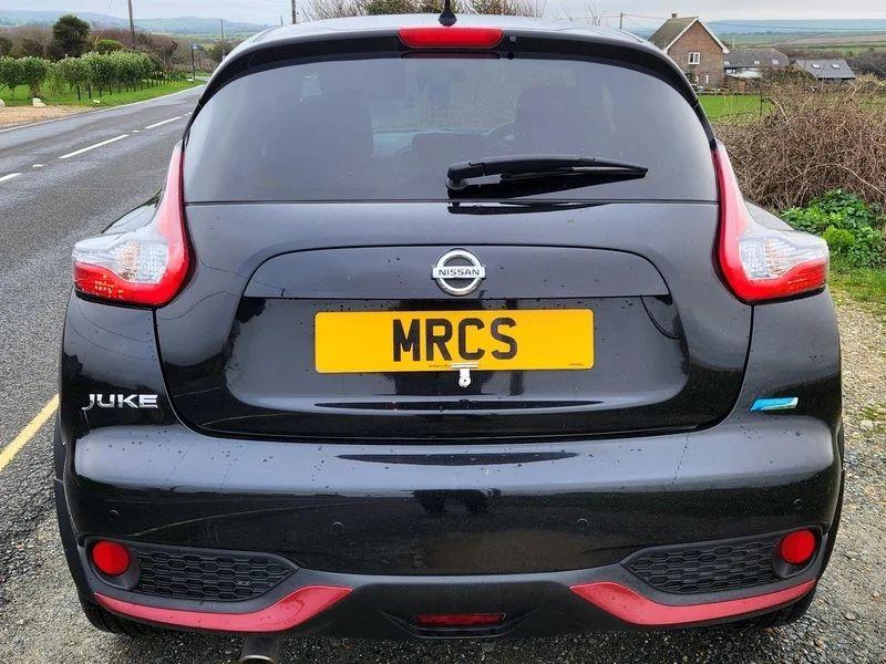 The back of a black Nissan Qashqai, with red reliefs, viewed from behind