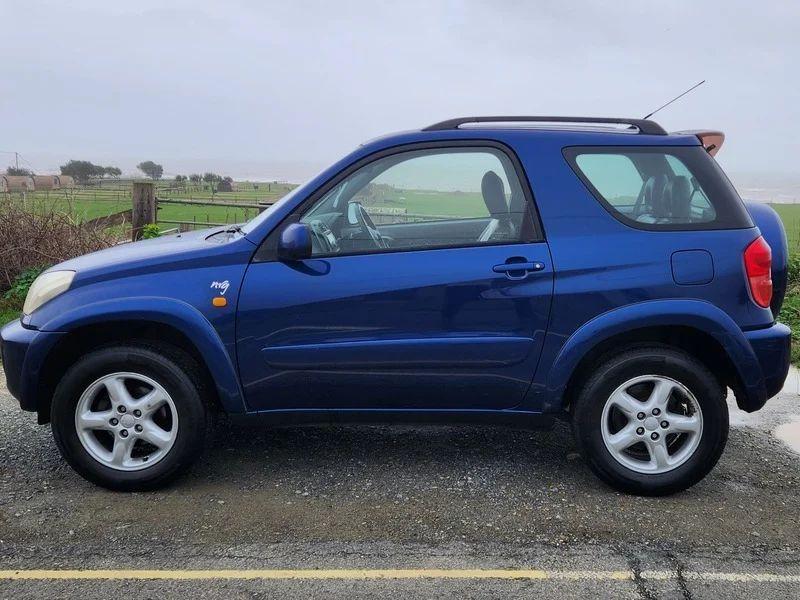 A Nebula Blue Metallic Toyota RAV4 viewed from the passenger side