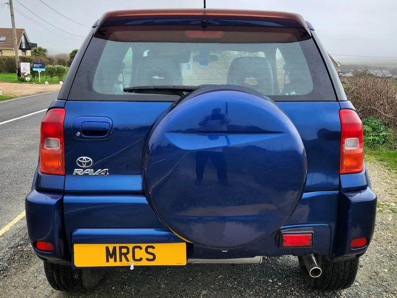 A Nebula Blue Metallic Toyota RAV4 viewed from behind
