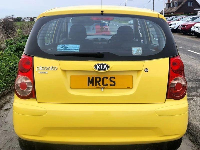 A yellow KIA Picanto viewed from the back