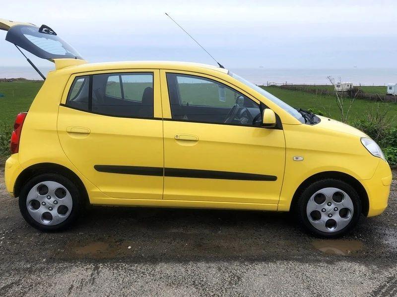 A yellow KIA Picanto viewed from the driver side