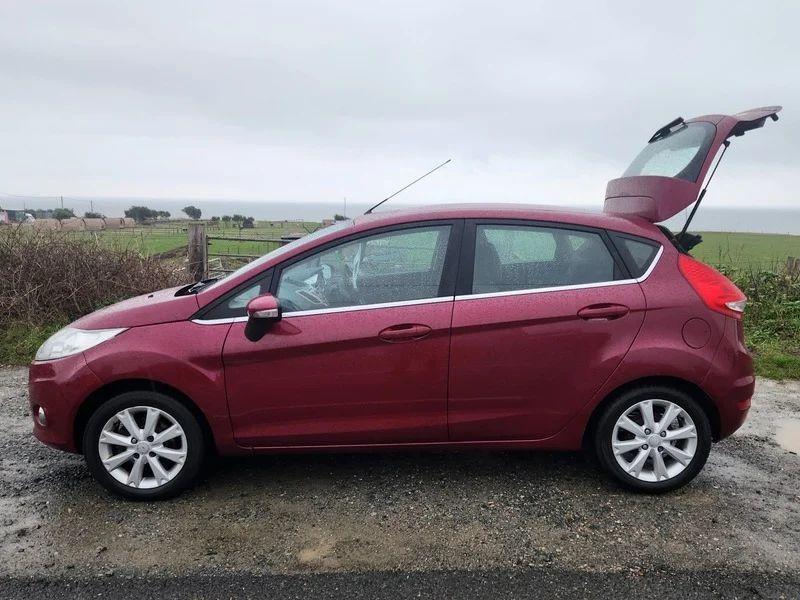 A Burgundy Ford Fiesta viewed from the passenger side