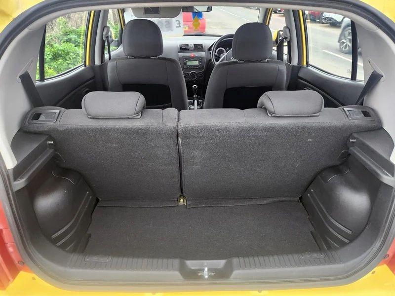 The open boot of a yellow KIA Picanto viewed from the back