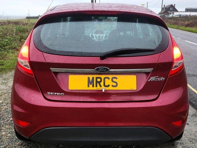 A Burgundy Ford Fiesta viewed from the back