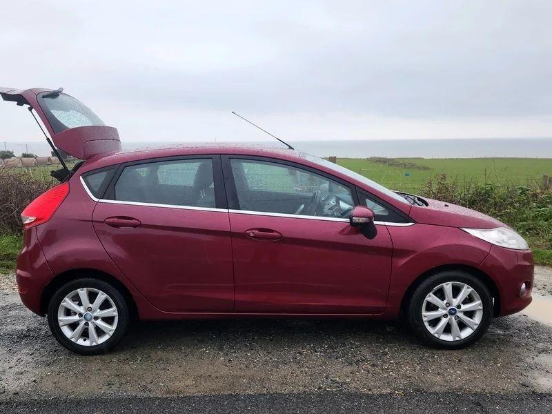 A Burgundy Ford Fiesta viewed from the driver side
