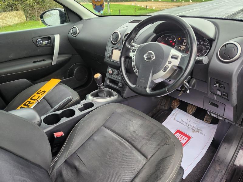 The steering controls of a black Nissan Qashqai Acenta viewed from above the driver seat