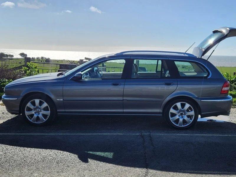 A grey Jaguar X viewed from the passenger side
