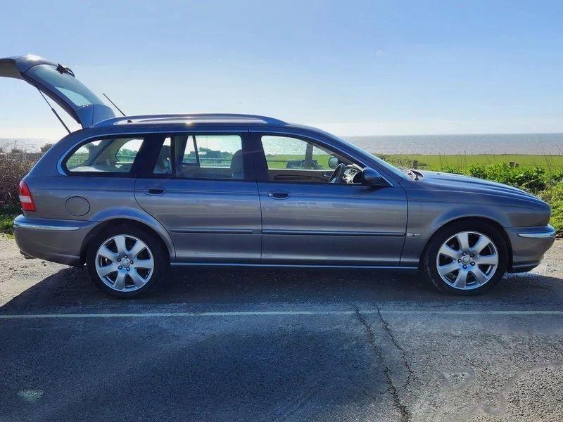 A grey Jaguar X viewed from the driver side