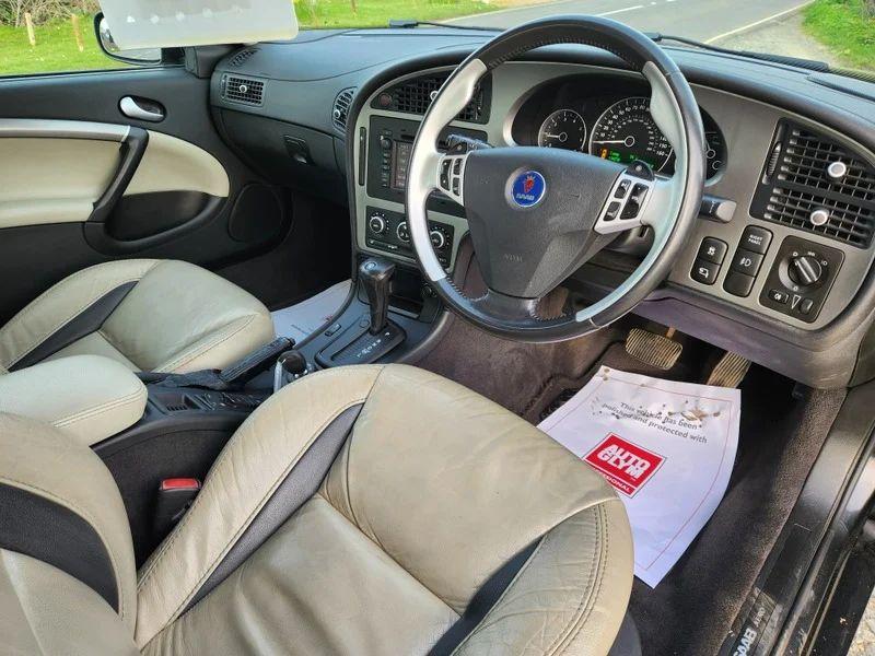 The steering controls of a black Saab 9-5 viewed from above the driver seat