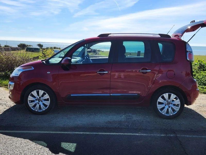 A red Citroen Picasso viewed from the passenger side