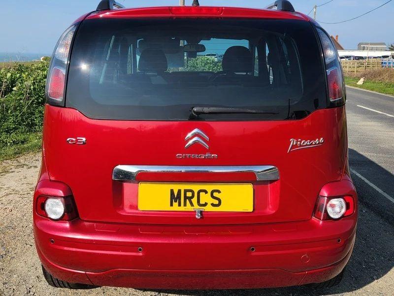 A red Citroen Picasso viewed from the back