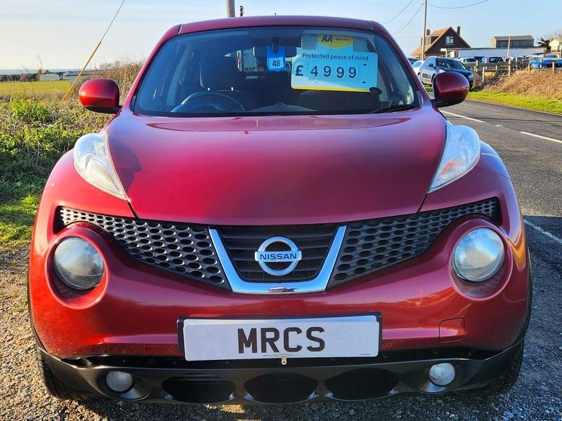 A red Nissan Juke Acenta viewed from the front