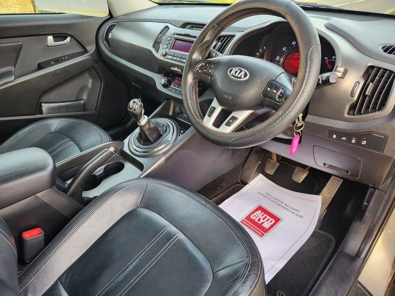 The steering controls of a bronze Kia Sportage 3 viewed from above the driver seat