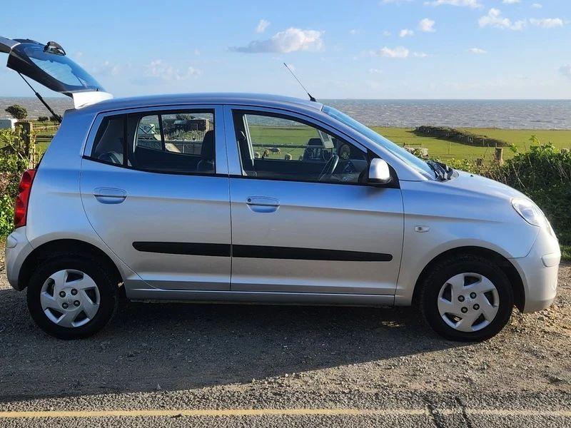 A sparkling silver metallic Kia Picanto viewed from the driver side
