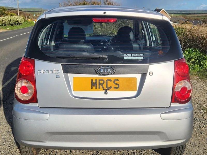 A sparkling silver metallic Kia Picanto viewed from the back