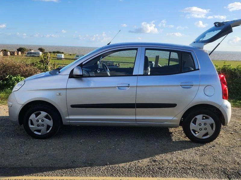 A sparkling silver metallic Kia Picanto viewed from the passenger side
