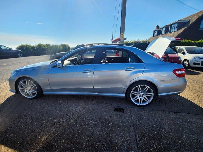 A Iridium Silver Mercedes E-Class viewed from the passenger side