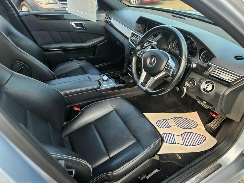 The steering controls of an Iridium Silver Mercedes E-Class viewed from above the driver seat