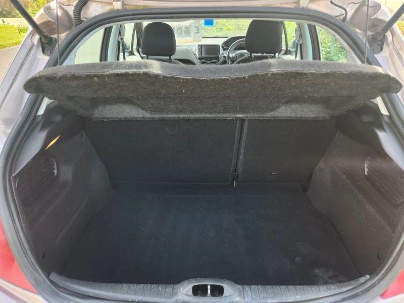 The open boot of a Peugeot 208 in Rose Pink Quartz Metallic viewed from the back