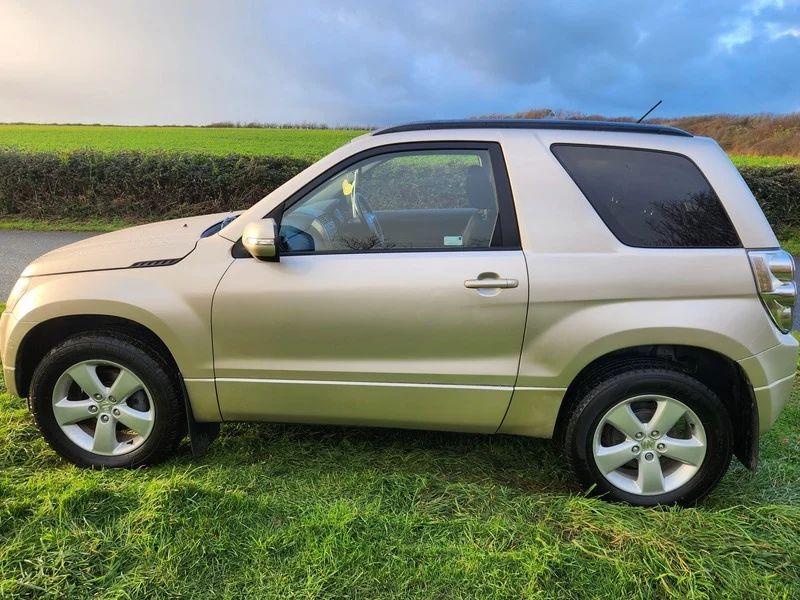 A Suzuki Grand Vitara in Mars Gold Metallicviewed from the passenger side