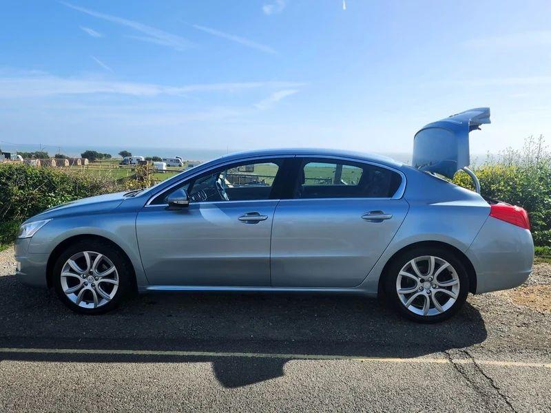 A Peugeot 508 Allure in Twilight Blue Metallic, viewed from the passenger side.