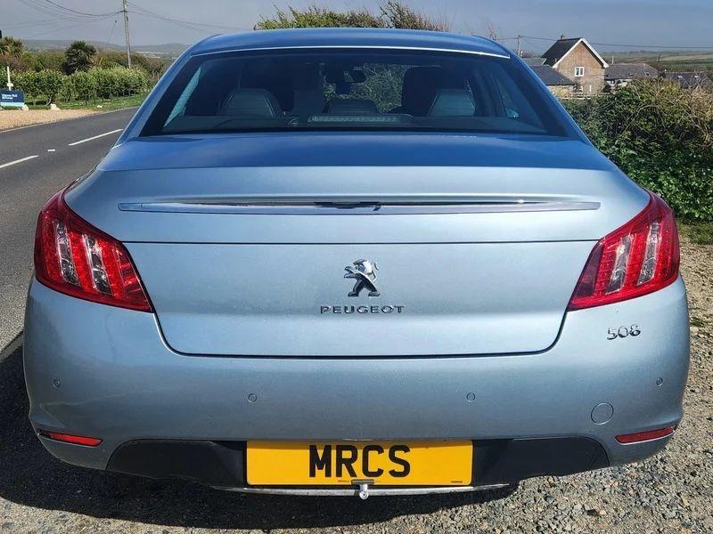 A Peugeot 508 Allure in Twilight Blue Metallic, viewed from the back.
