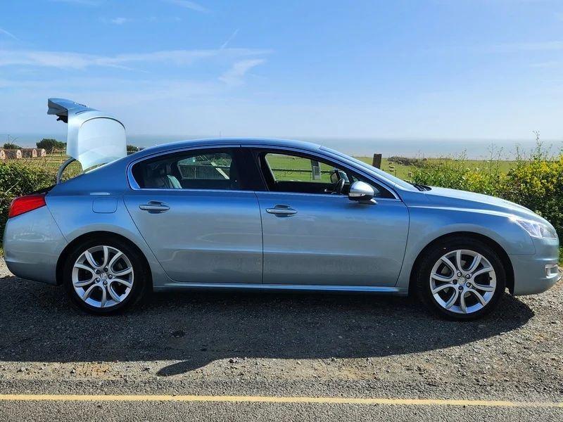 A Peugeot 508 Allure in Twilight Blue Metallic, viewed from the driver side.