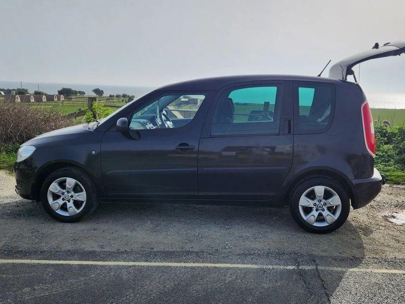 A Skoda Roomster in Jet Black Metallic viewed from the passenger side