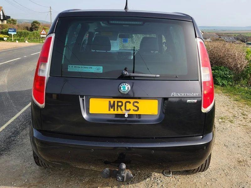 A Skoda Roomster in Jet Black Metallic, viewed from the back.