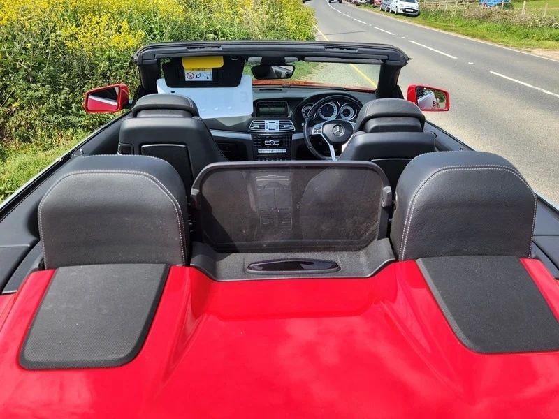 An open topped red Mercedes viewed from the back