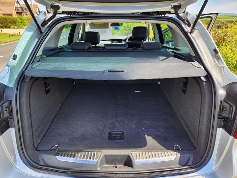 The open boot of a silver Renault Laguna estate viewed from the back
