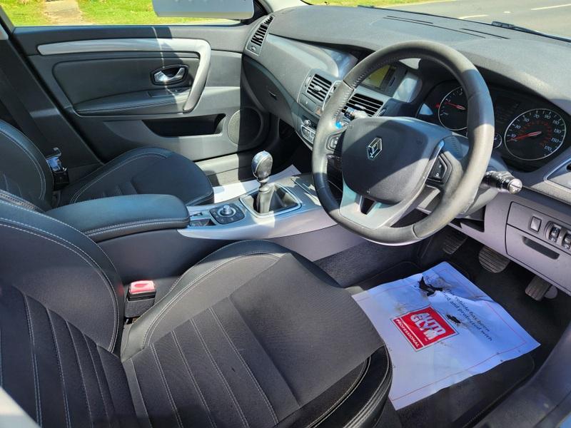 The steering controls of a silver Renault Laguna estate viewed from above the driver seat