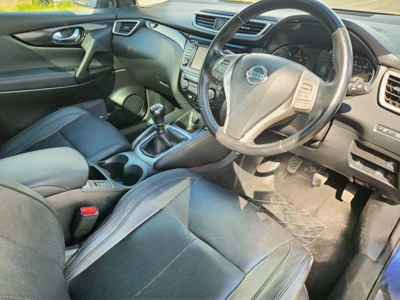 The steering controls of a blue Nissan Qashqai SUV viewed from above the driver seat