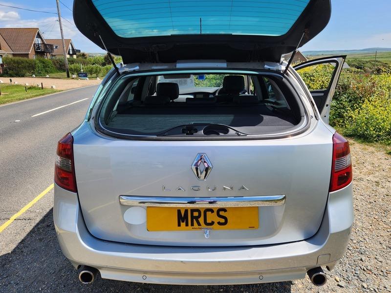 A silver Renault Laguna estate viewed from the back with the flap up
