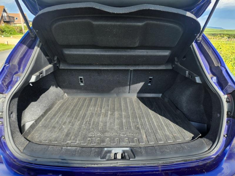 The open boot of a blue Nissan Qashqai SUV viewed from the back