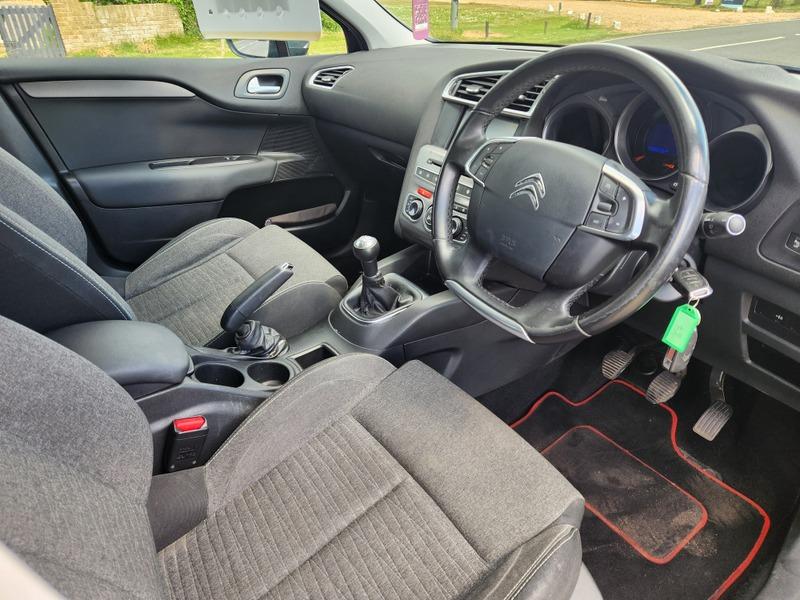 The steering controls of a black Citroen C4 viewed from above the driver seat