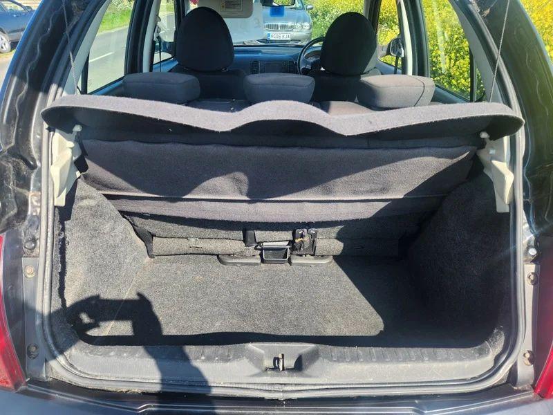 The open boot of a black Nissan Micra viewed from the back