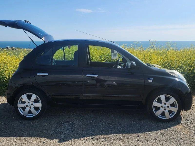 A black Nissan Micra viewed from the driver side