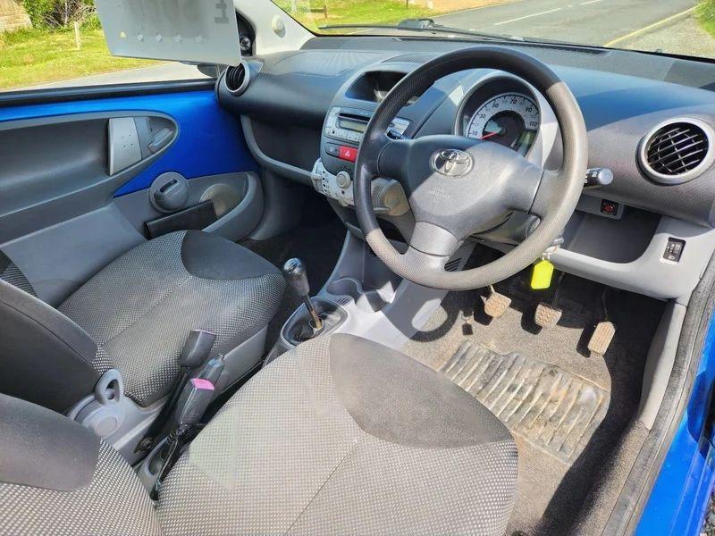 The steering controls of a blue Toyota Aygo viewed from above the driver seat